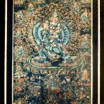 Scroll painting (thangka) on cotton, black background, central figure is wrathful Buddhist deity Vajrabhairava, who has 34 arms and a buffalo head. In his hands he holds various weapons and power objects. He is surrounded by other deties. 